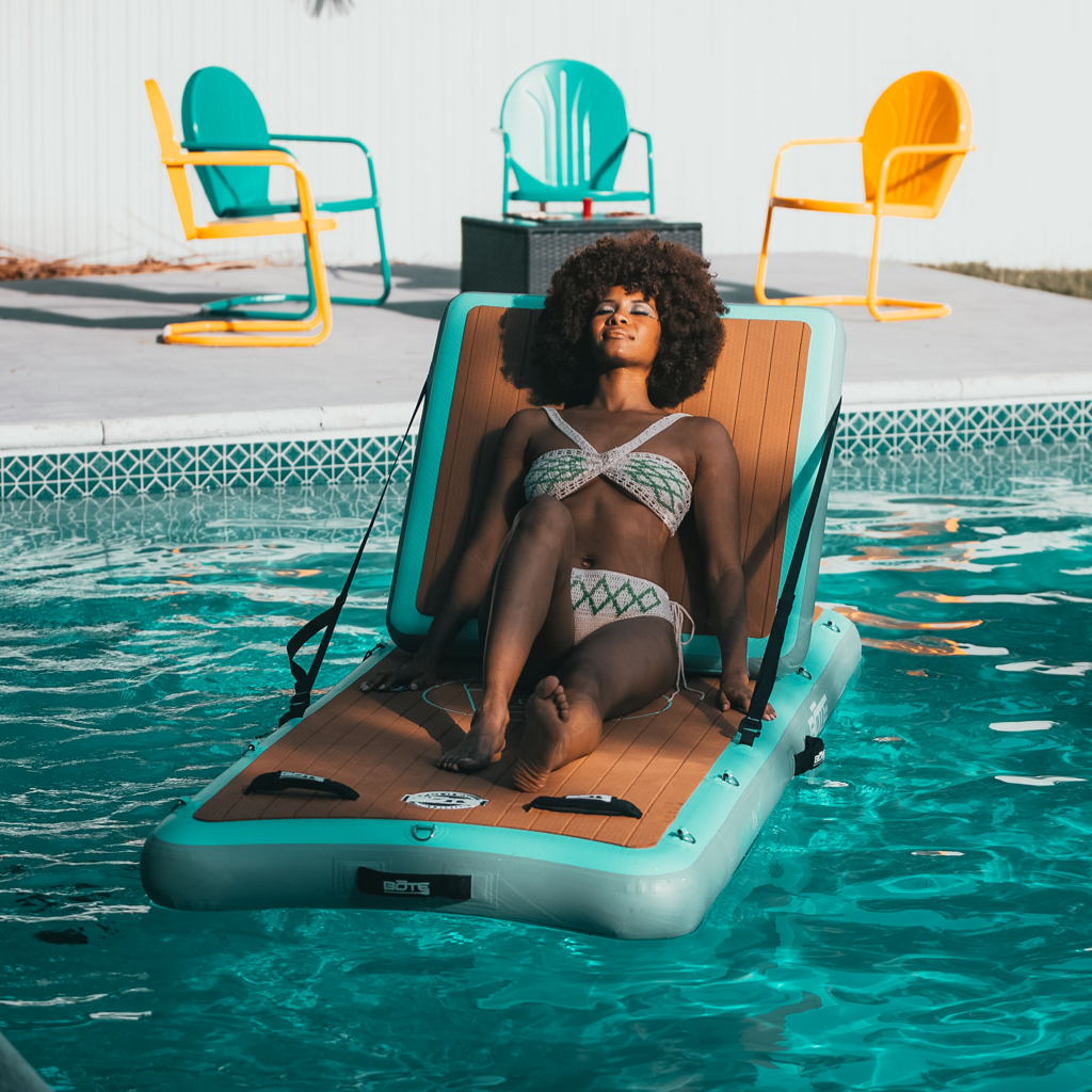 A woman lounging on the Inflatable Hangout Lounge Classic.