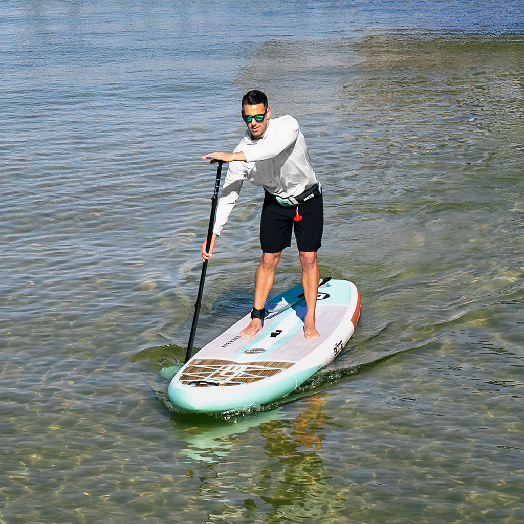 Man paddleboarding on a clear body of water