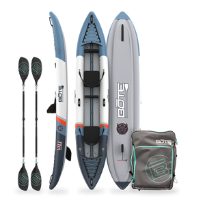 Inflatable kayak with paddles and a carrying bag.