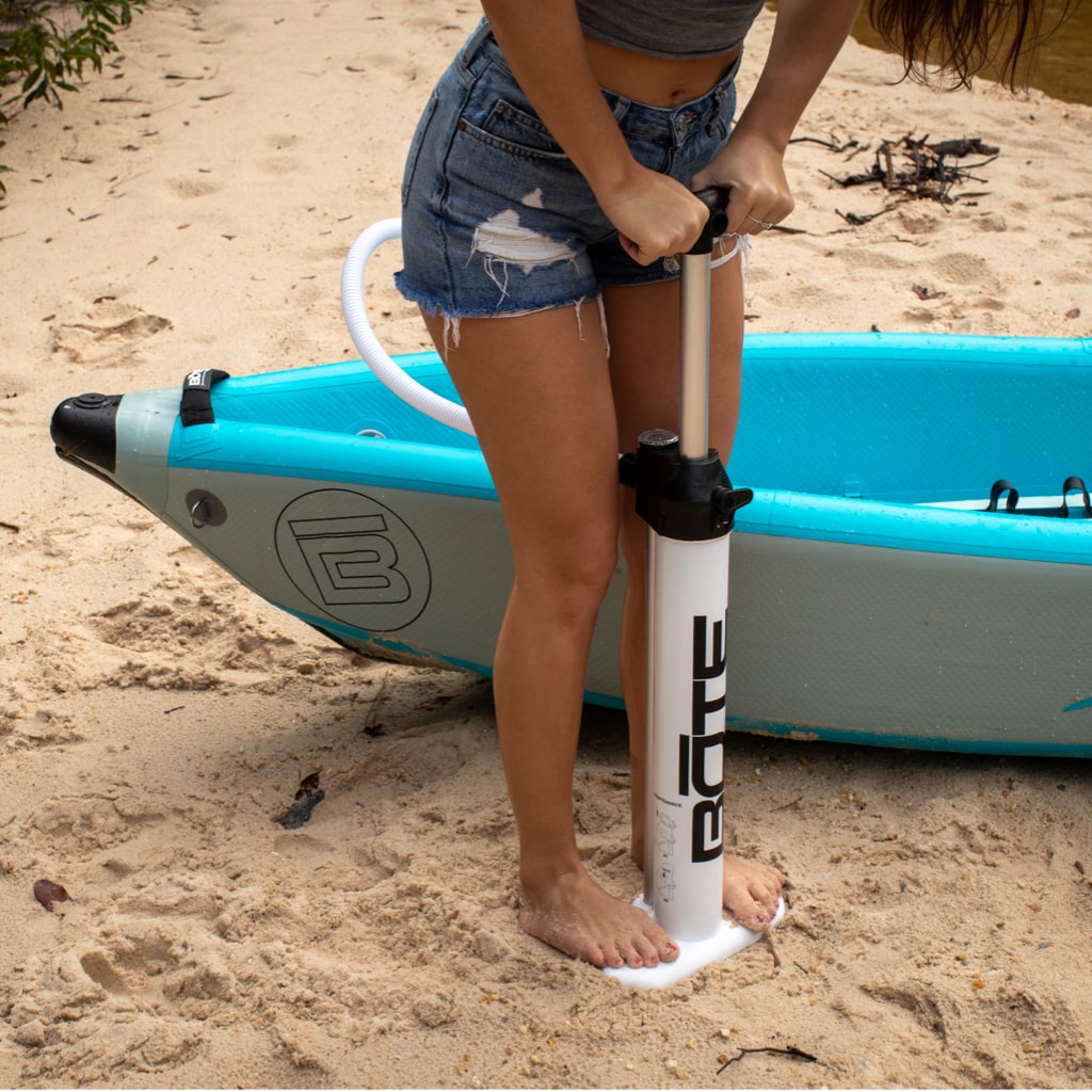 A person using the Side view of the Aero Hand Pump to pump a kayak