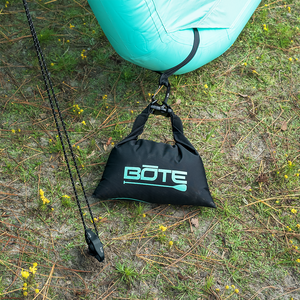 Top view of Anchor Kit clipped to an aqua inflatable float on grass.