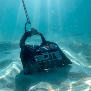 Underwater view of Anchor Kit clipped to a BOTE logo bag on a sandy bottom.