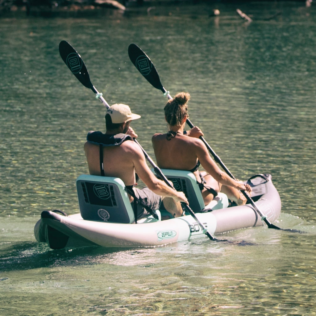 Man and woman paddling on the Zeppelin Aero Inflatable Kayak with two Zeppelin Aero Kayak Seats.