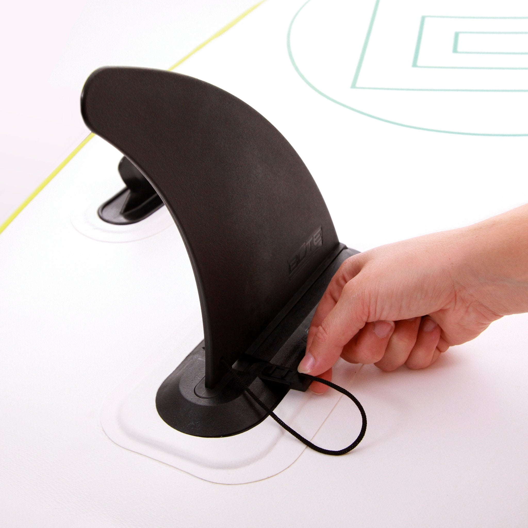 Hand securing the Replacement Aero Center Fin onto an inflatable board using a tethered clip.