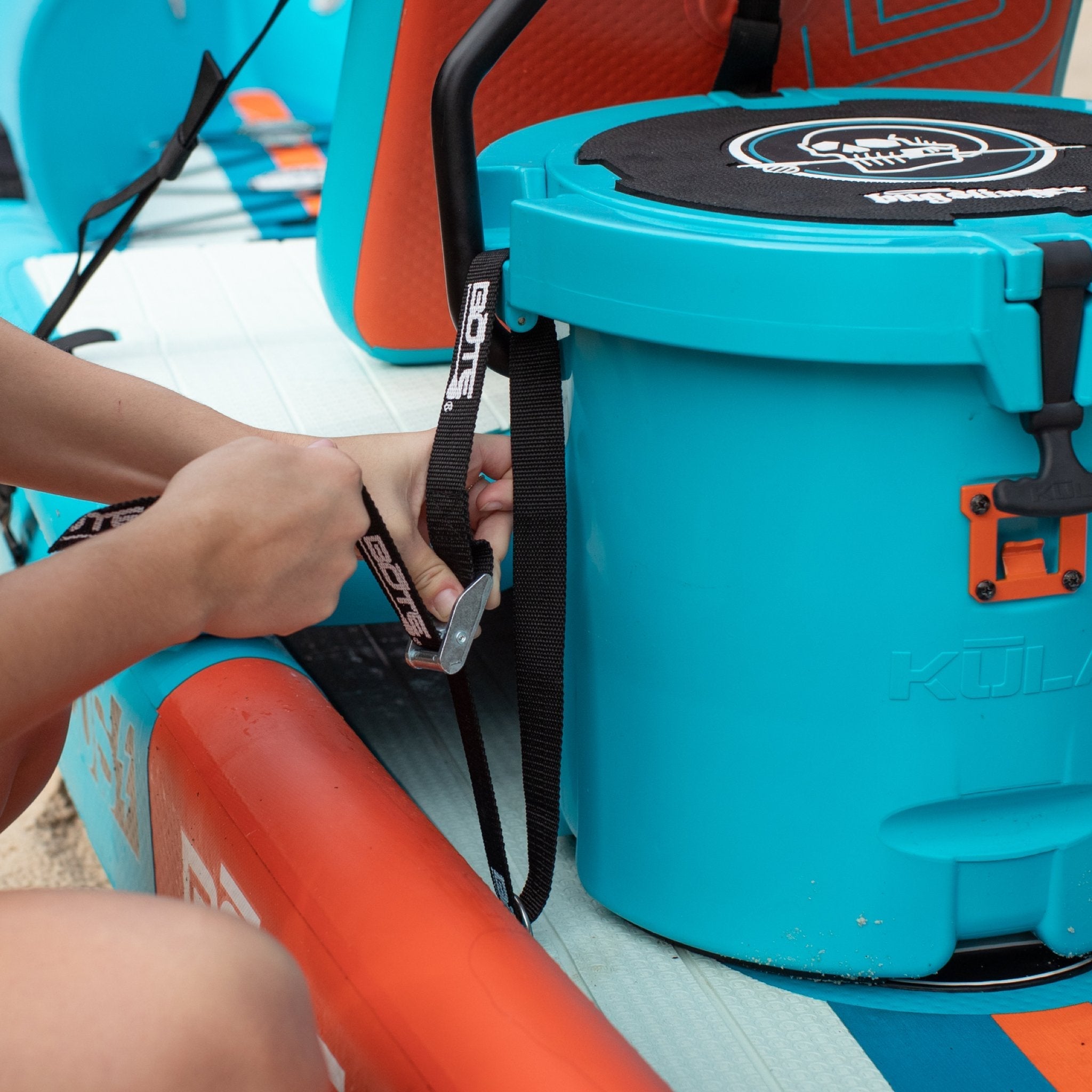 The Cooler Tie-Down Kit being put on a DEUS kayak with cooler